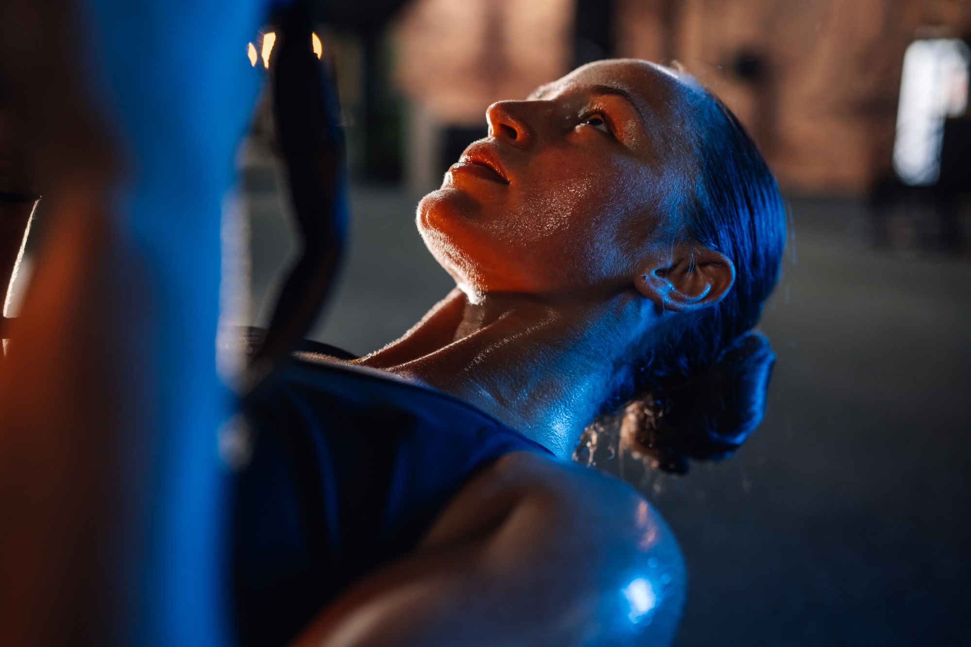 Young athletic woman is working out with battle ropes in a gym